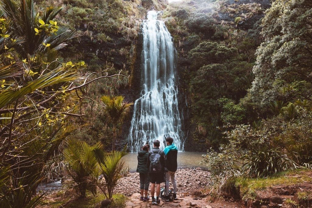 friends standing at karekare falls