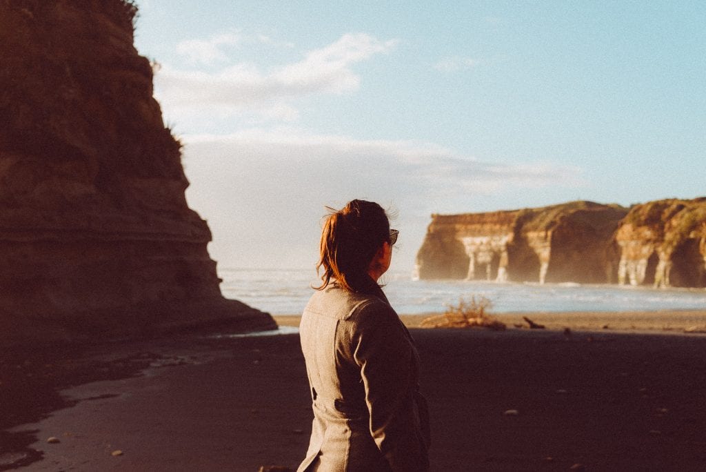 a woman looking at the cliffs at tongaporutu in taranaki